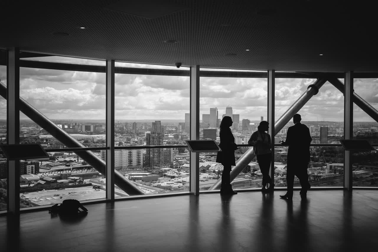 Vista de uma cidade a partir de um edifício corporativo, com pessoas em conversa